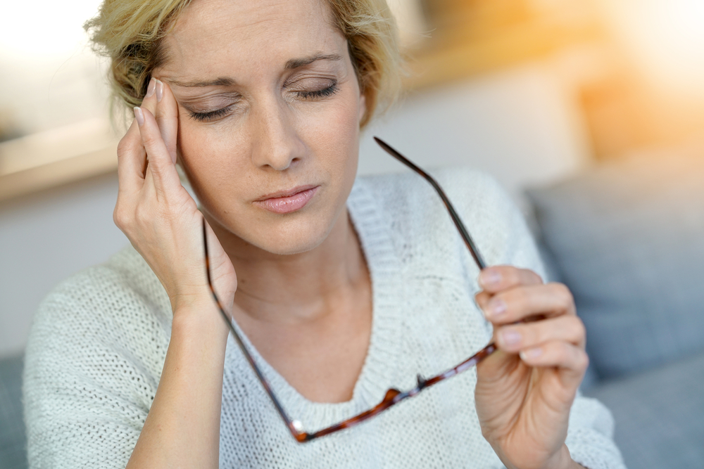Image of a middle-aged blond woman having a migraine