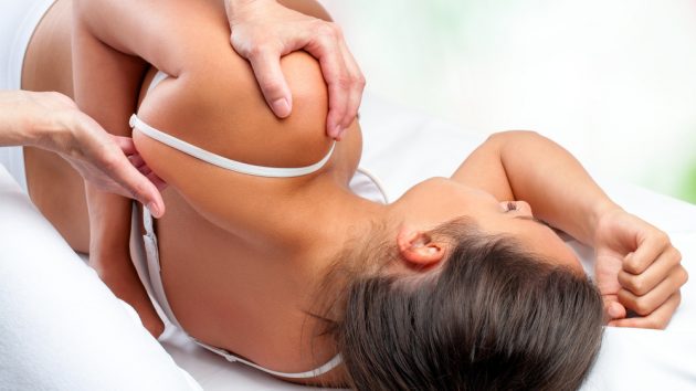 Close up top view of osteopath doing healing treatment on female shoulder blade, Image by city osteopathy